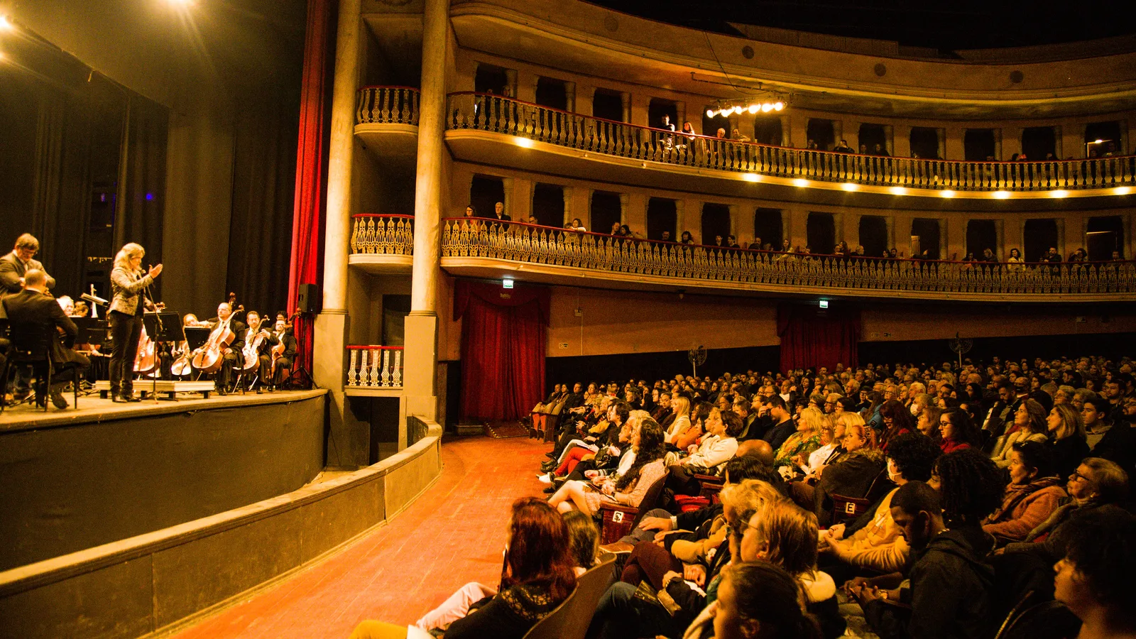Orquestra sinfônica se apresenta em teatro lotado