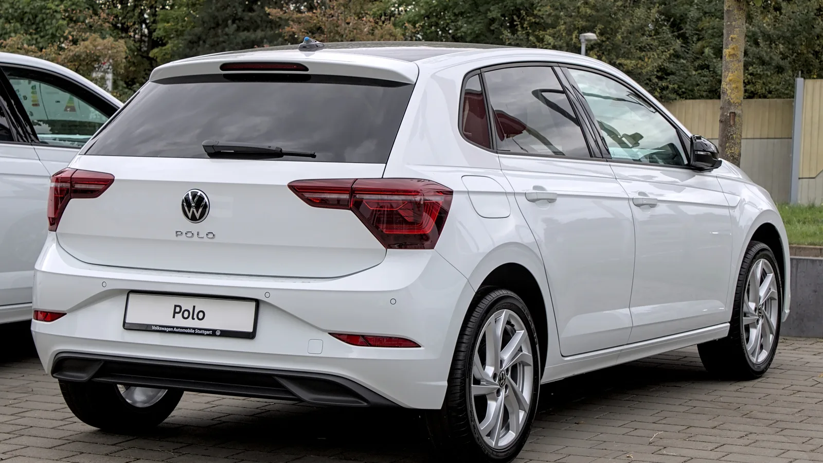 Volkswagen Polo branco visto de trás, estacionado em pátio