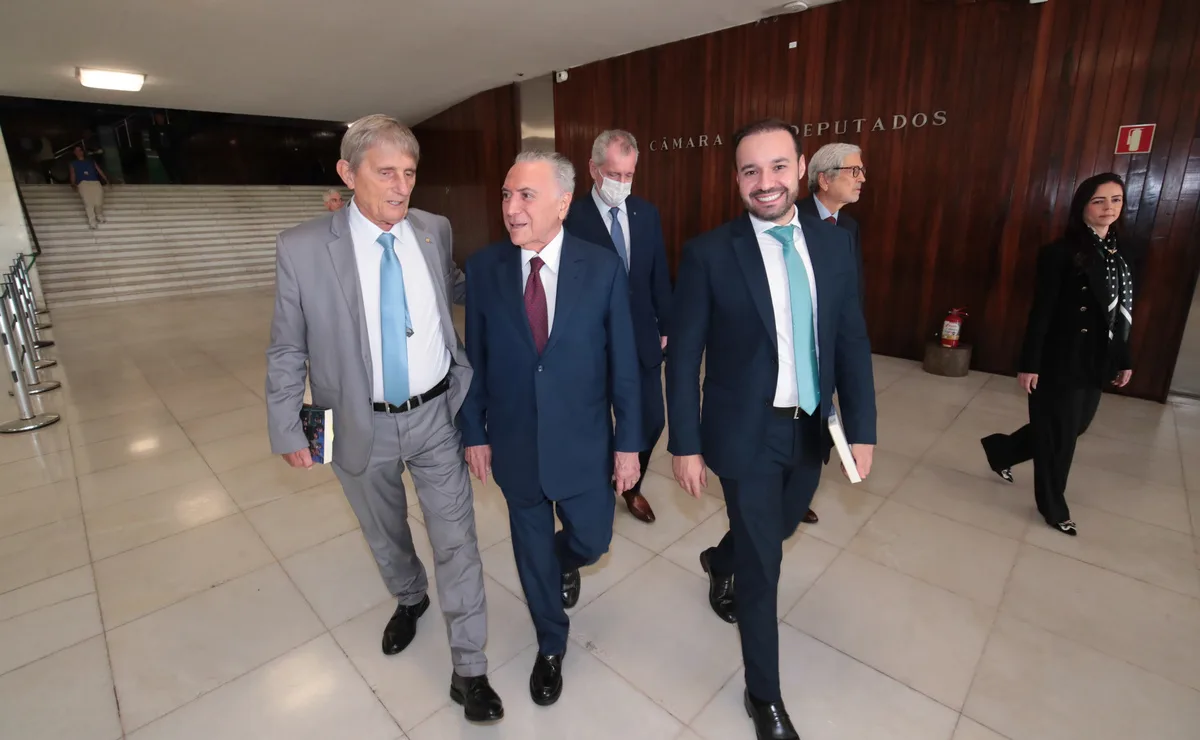 Michel Temer caminha ao lado de outros parlamentares em corredor da Câmara dos Deputados