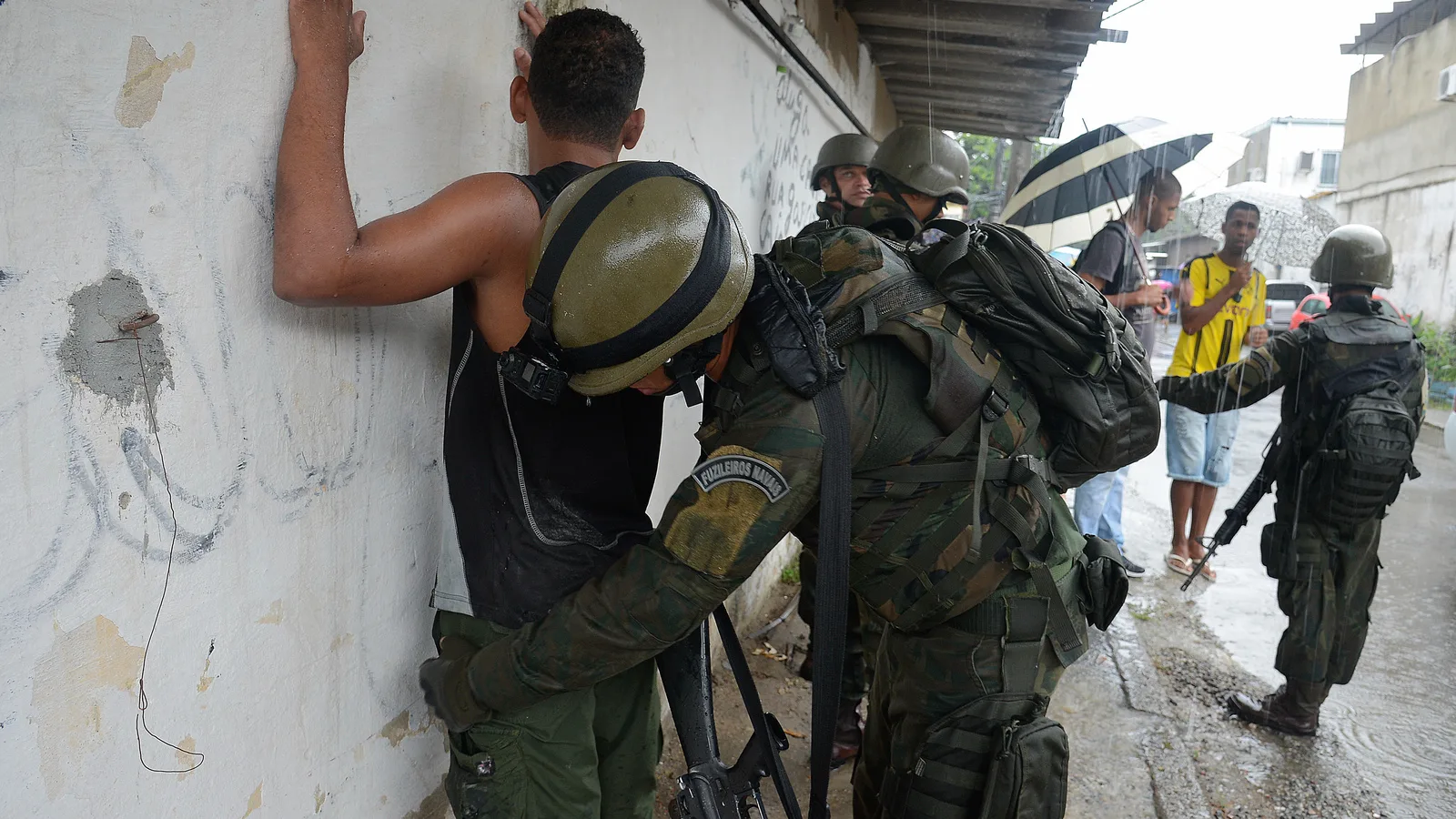 Agente de segurança revista suspeito durante operação policial no Rio de Janeiro