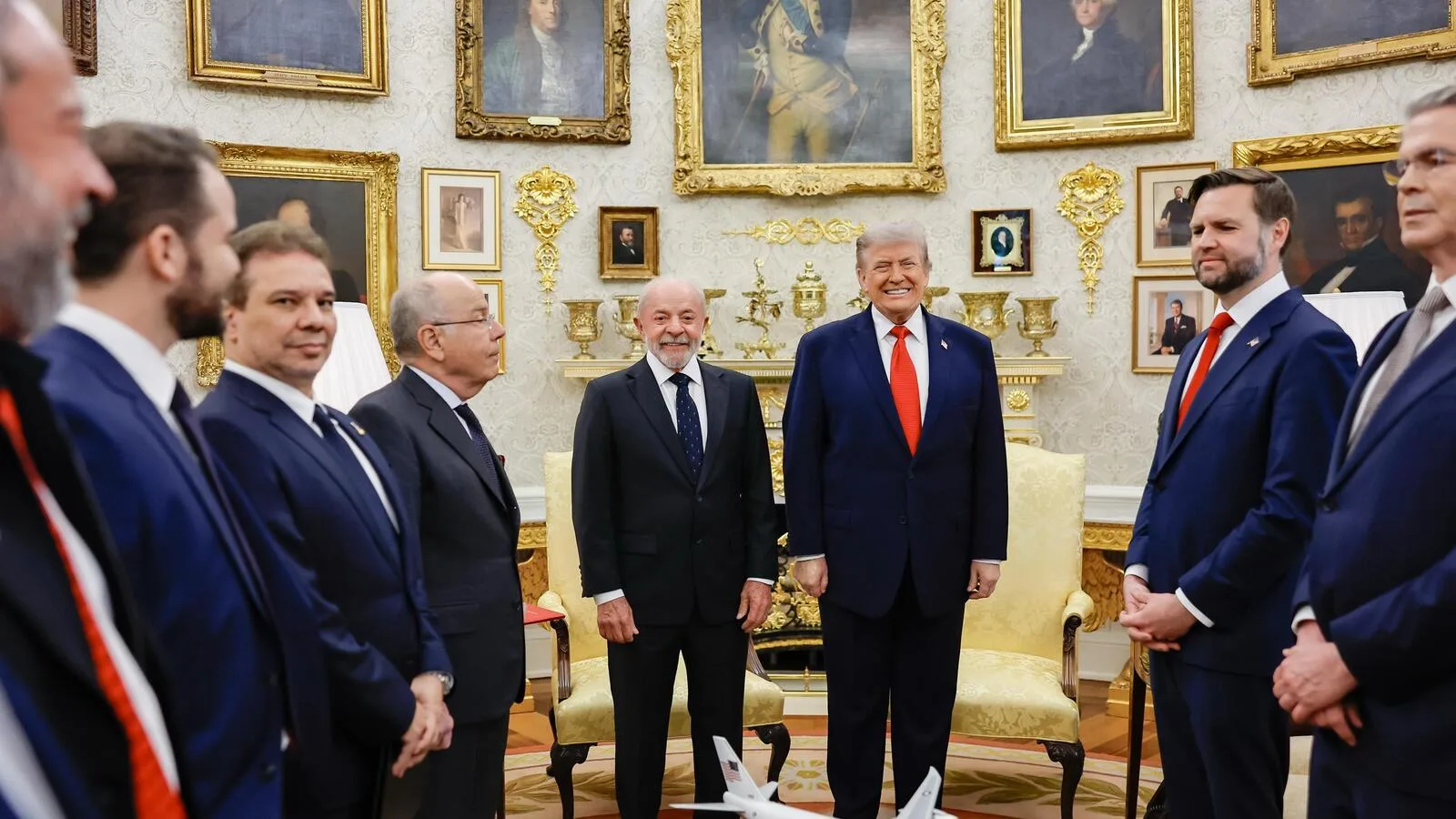 Donald Trump em encontro oficial com autoridades, ao lado de bandeiras
