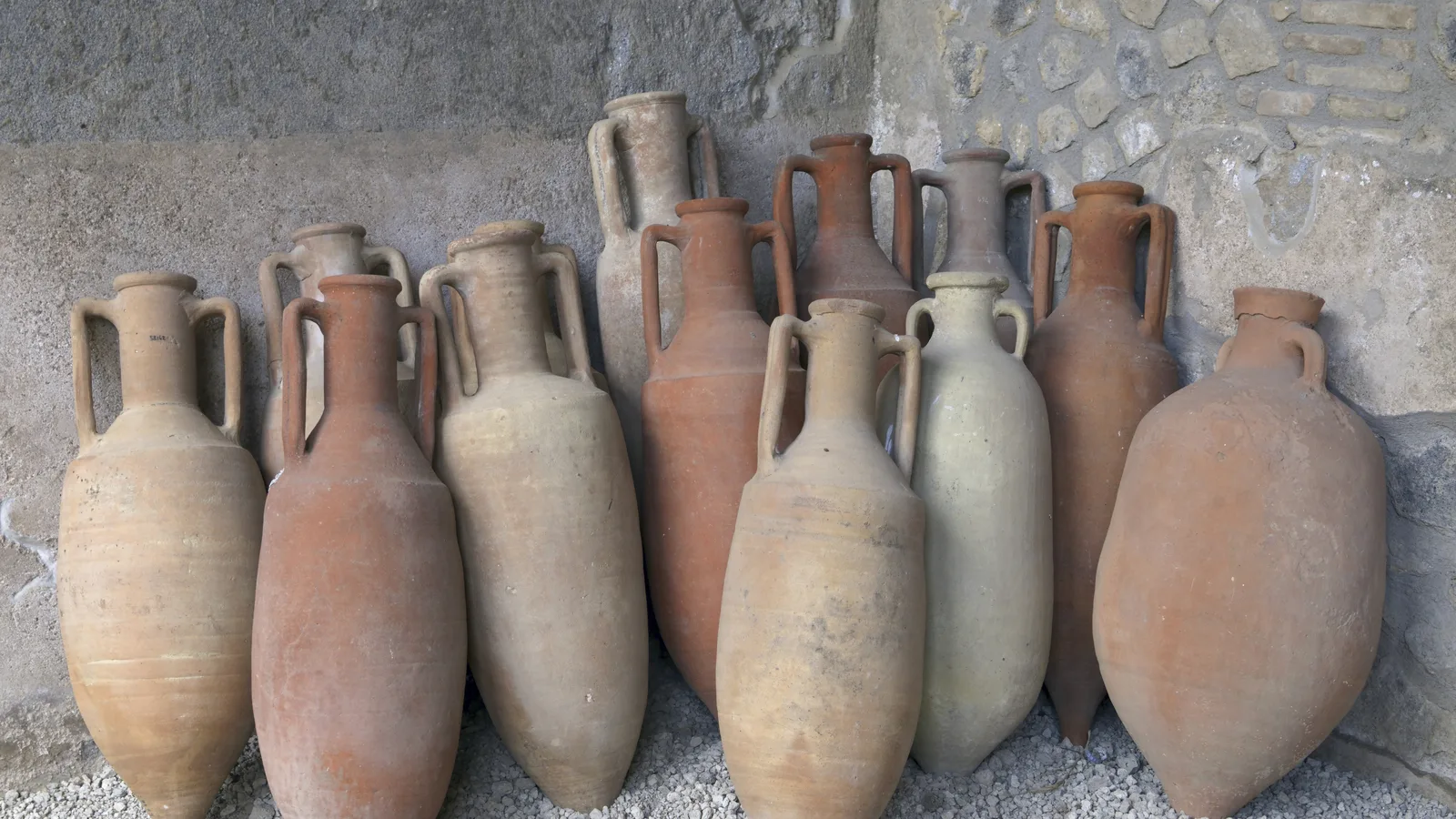Fileira de ânforas antigas de cerâmica, usadas para transporte marítimo
