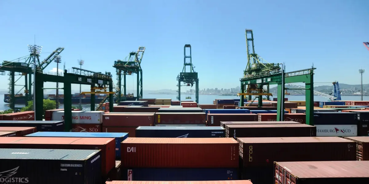 Contêineres empilhados em porto brasileiro durante operação de exportação