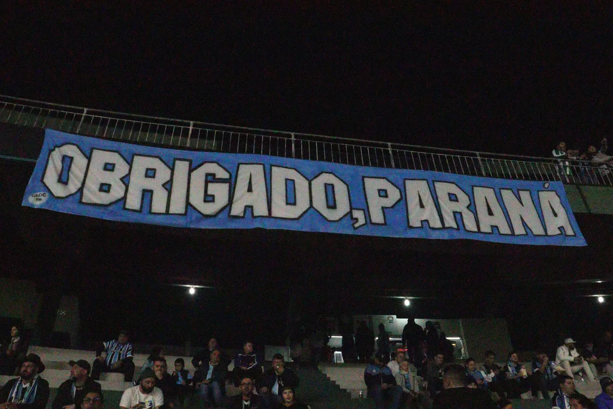Torcedores do Grêmio seguram faixa escrita 'Obrigado, Paraná' nas arquibancadas do Couto Pereira
