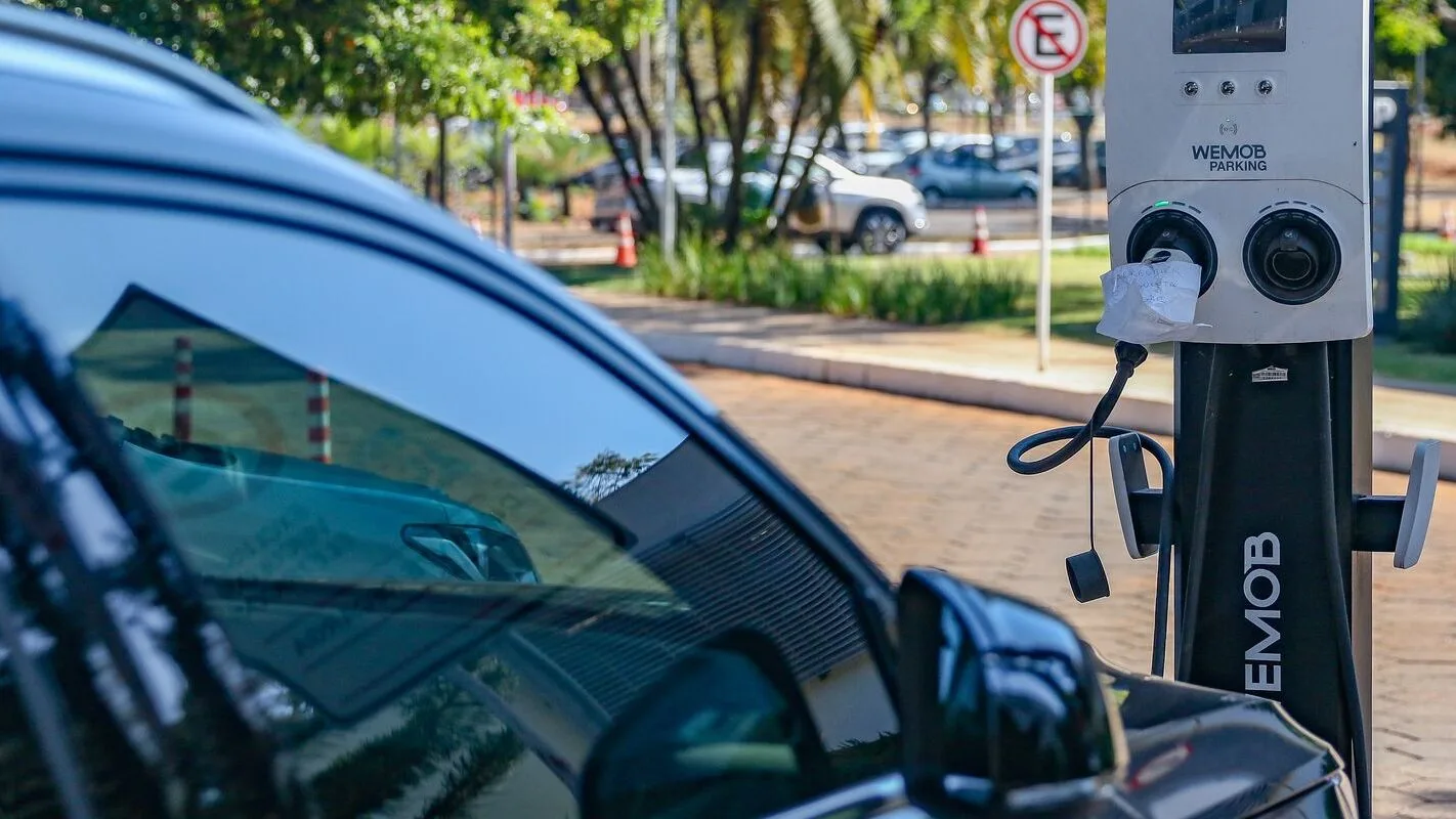 Carro elétrico conectado a um ponto de recarga pública no Brasil