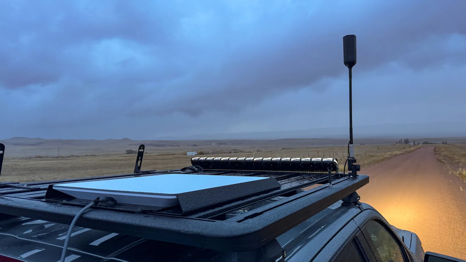 Antena da Starlink instalada no teto de um veículo em estrada de terra