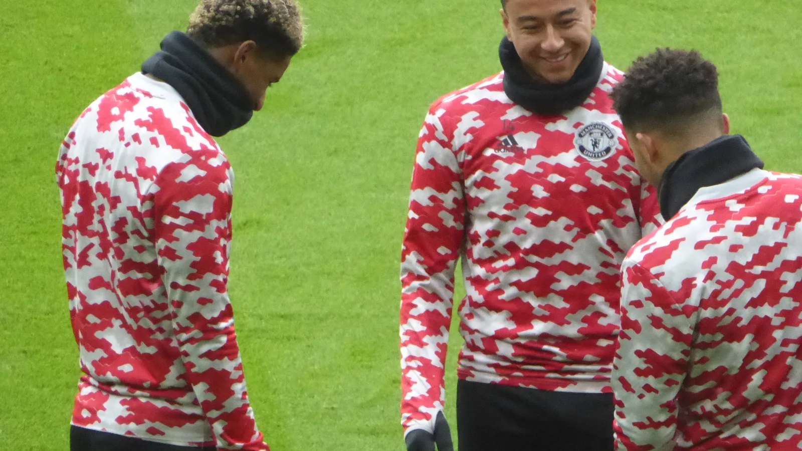 Jesse Lingard sorri ao lado de companheiros durante aquecimento em campo